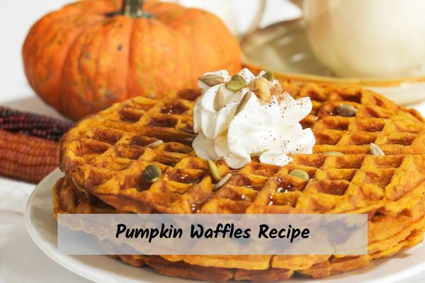 Pumpkin_Waffles_Recipe Pumpkin waffles topped with pumpkin seeds and whipped cream.