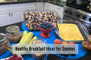 display of a variety of breakfast foods including baked oatmeal, muffins, chia pudding, frittata, bananas and blueberries 