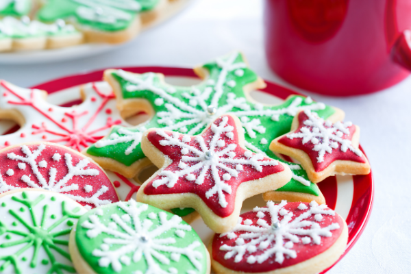 Star shaped sugar cookies frosted in red and green with white snowfakes drawn on them