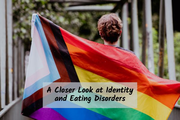 an individual holding up the 2SLGBTQIA+ flag