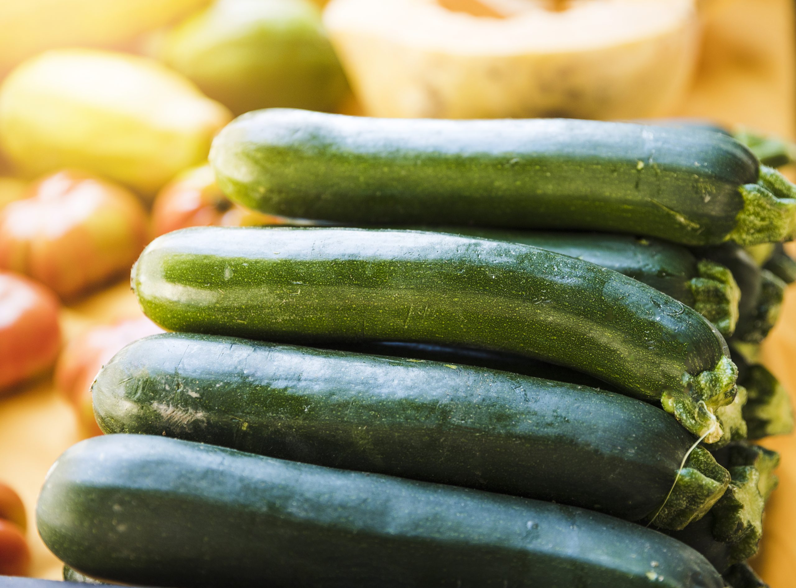 close-up-staked-green-farm-fresh-zucchini-sale zucchini stacked at a table as a cheap vegetable choice