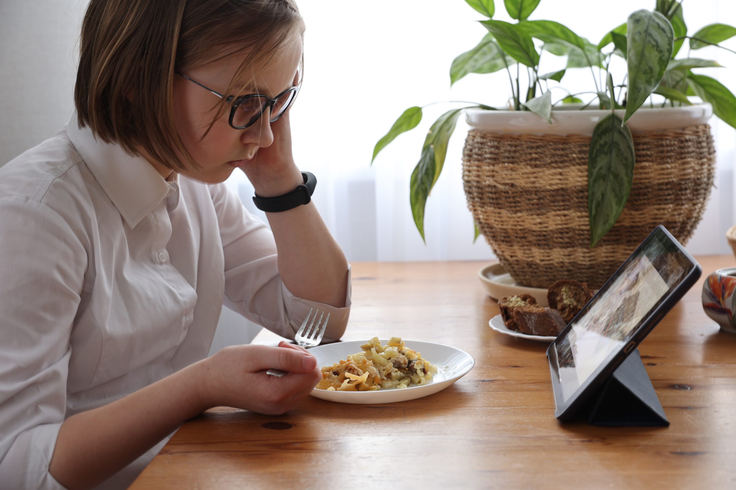 Girl eats lunch with tablet person with ARFID eating