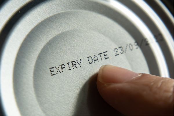 Expiry vs Best Before Date Difference Tips a finger pointing to an expiry date on a can and understanding the difference between expiry and best before dates