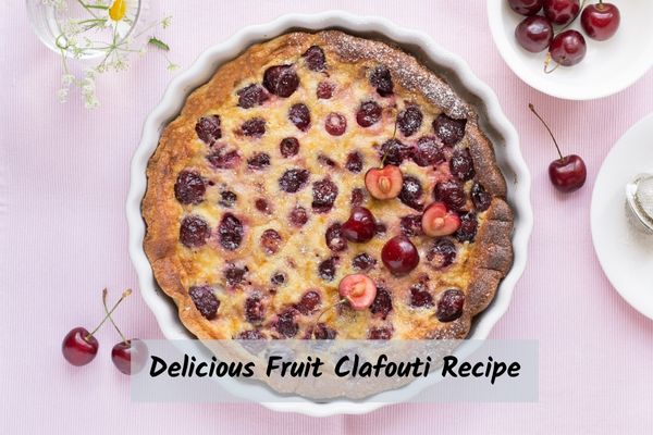 a fruit clafouti recipe with cherries on a pink table