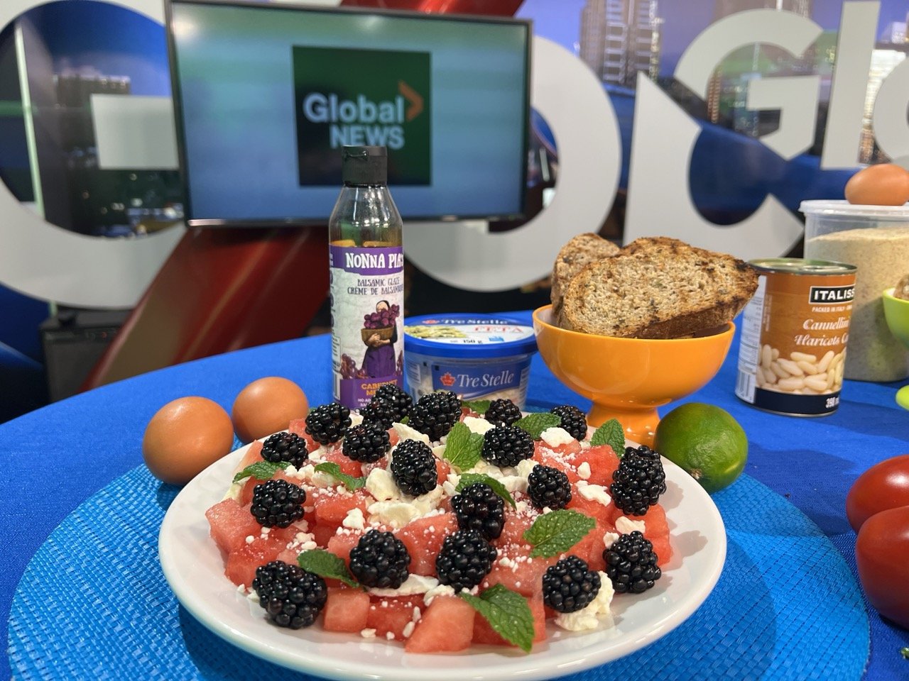summer salad that has watermelon feta and blackberries with garlic toast on a plate