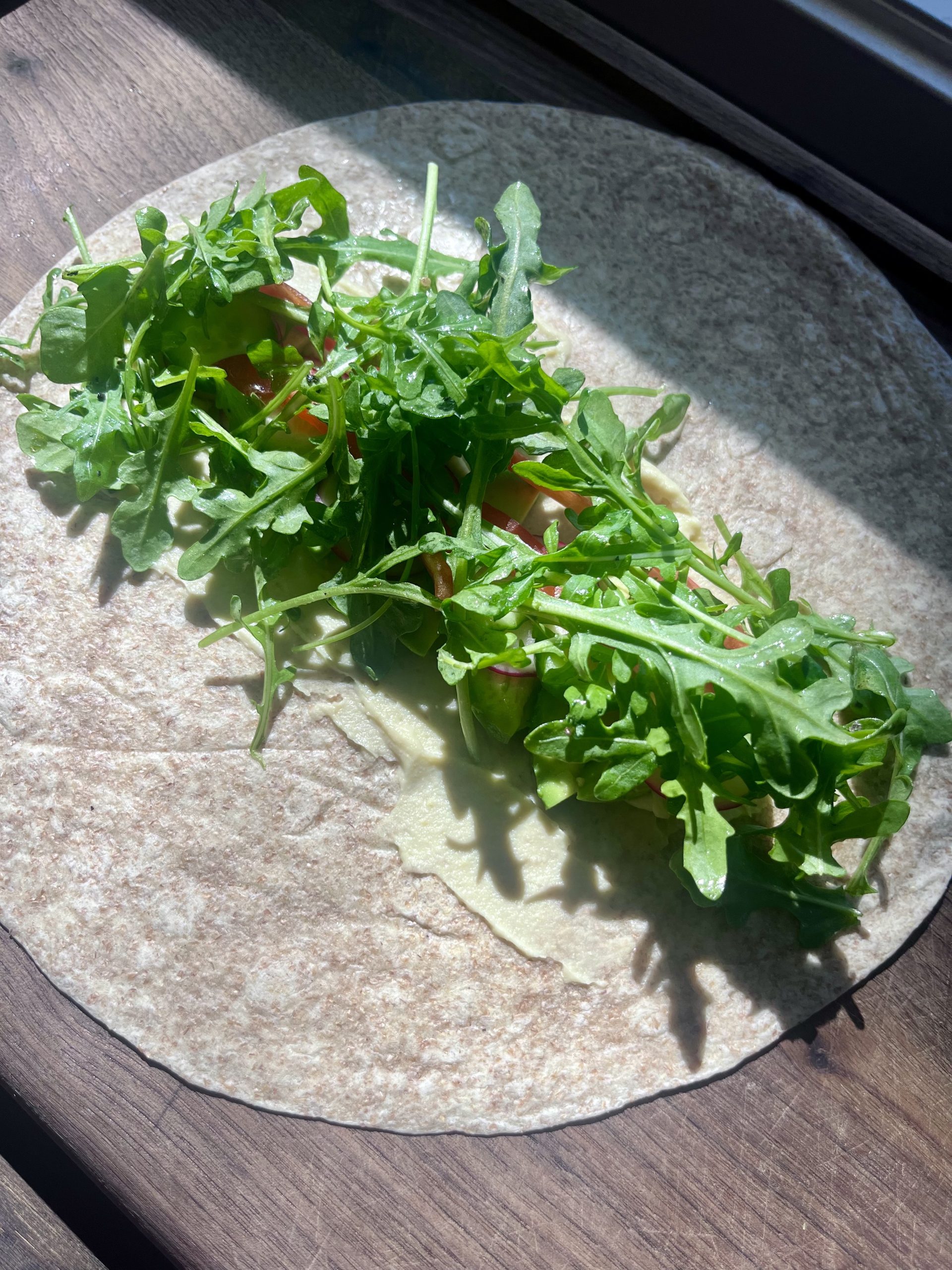 Hummus veggie wrap with seasoned arugula