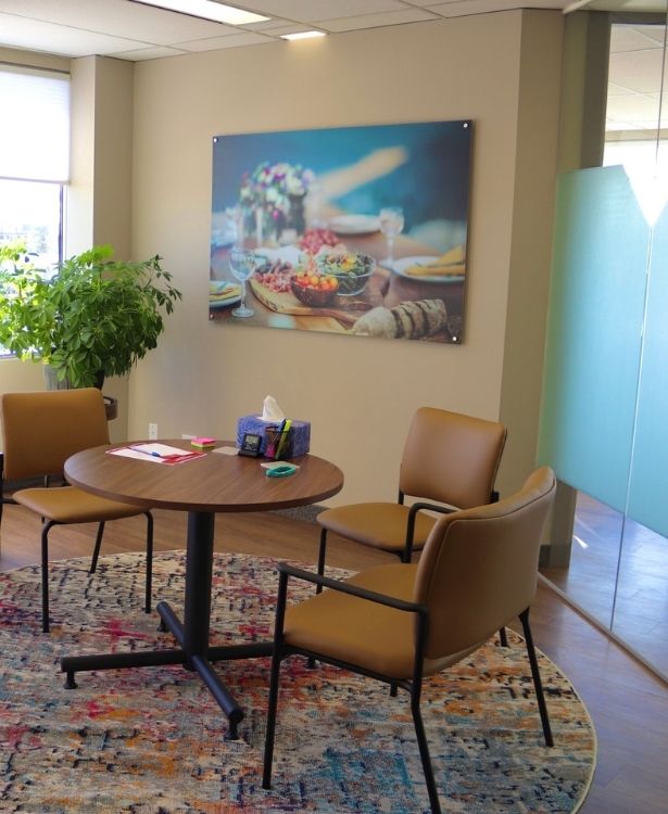 Calgary_Nutritionist_Office three chairs around a round table with a food background in a Calgary Dietitian's Office