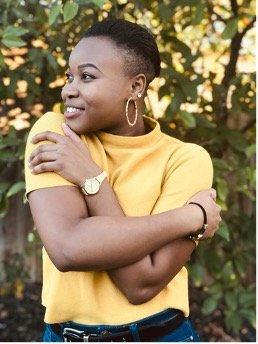 A person in a yellow shirt giving themself a hug.