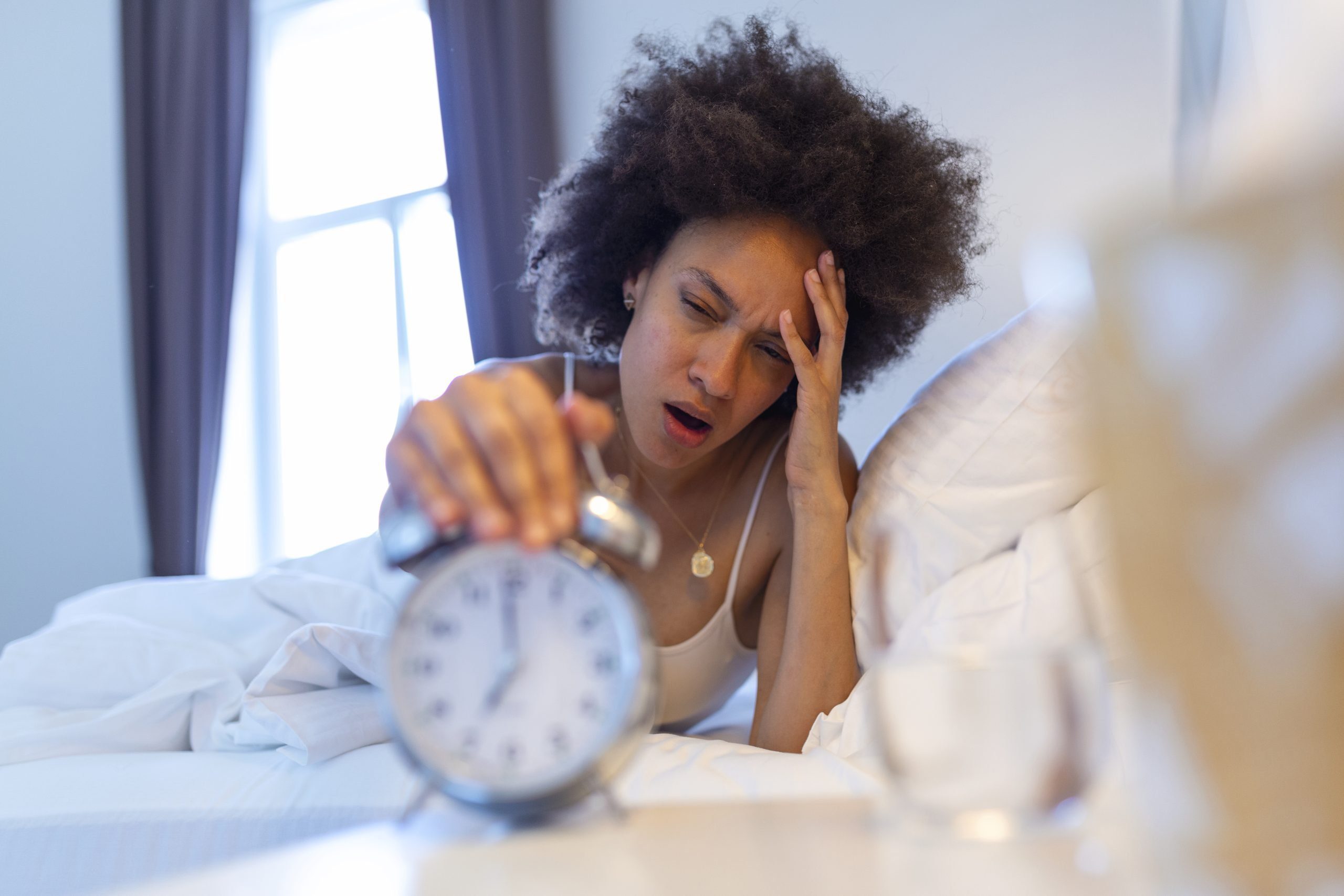 Doctor holding a blood test tube Person waking up tired and turning off their alarm clock