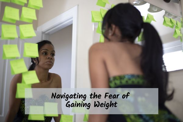woman looking into a mirror with sticky notes lining the edges of the mirror