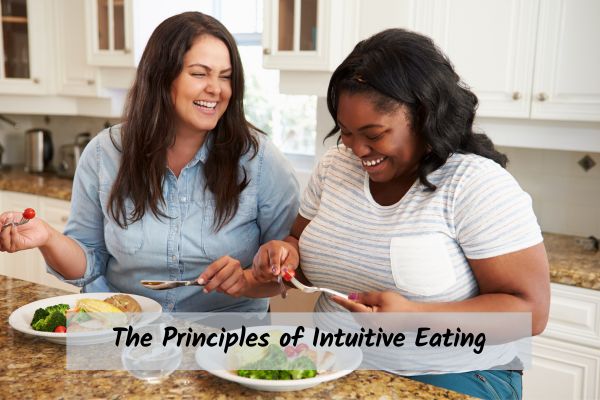Principles-of-intuitive-eating two women laughing together eating food and talking about intuitive eating