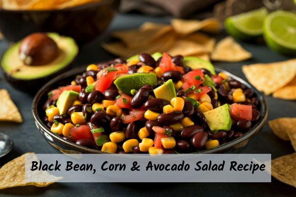 Black bean, corn, and avocado salad recipe in a bowl with avocados in the back