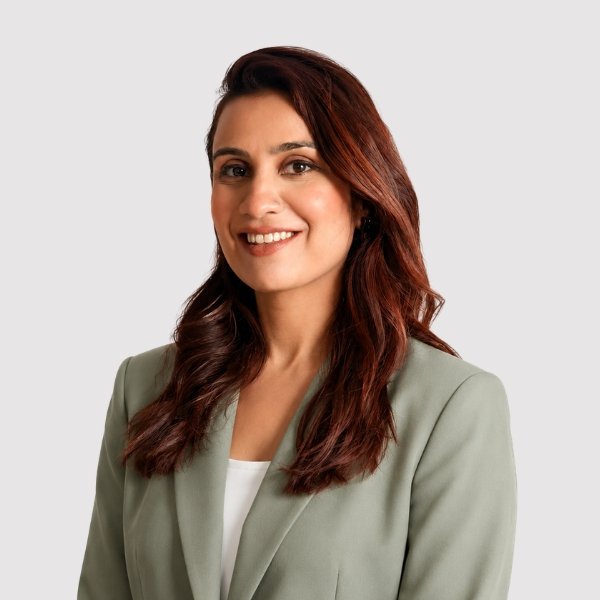 registered dietitian hibba nawaz smiling wearing a green blazer