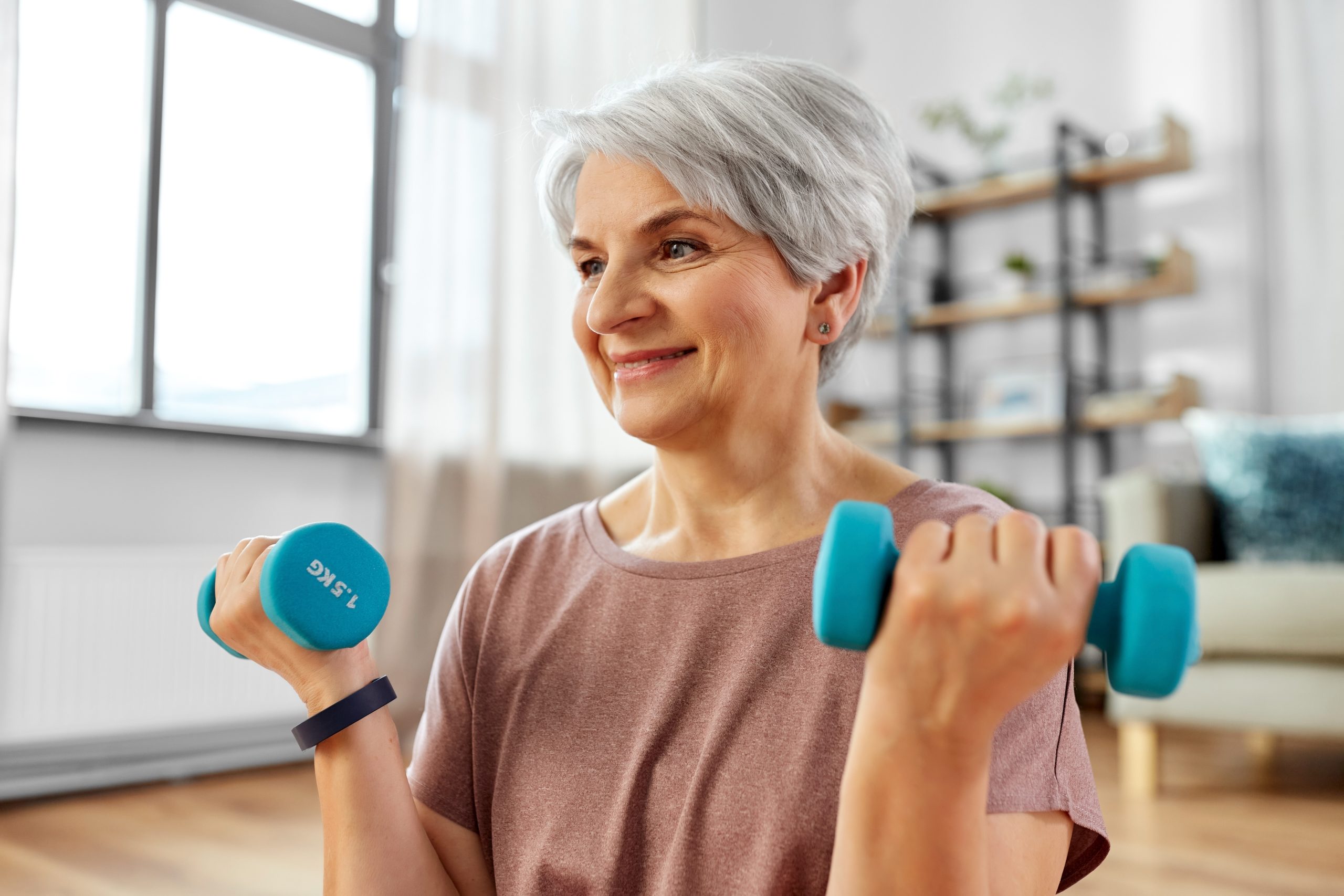 senior woman with dumbbells exercising at home senior woman with dumbbells exercising at home to protect bones
